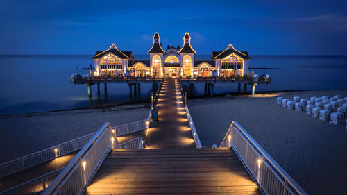 Pier amidst sea against sky at dusk