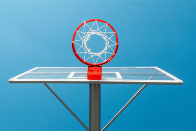 Low angle view of basketball hoop against blue sky