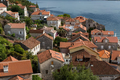 Perast, roofs of old houses in perast and bay with mountains in montenegro 