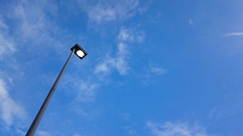 Low angle view of street light against blue sky