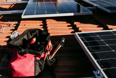 Bag of technician tools and solar panel on roof during sunrise.renewable energies and green energy