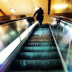 Woman standing on escalator