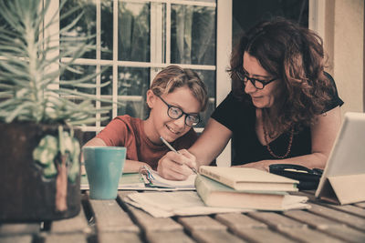 Mother teaching son on table