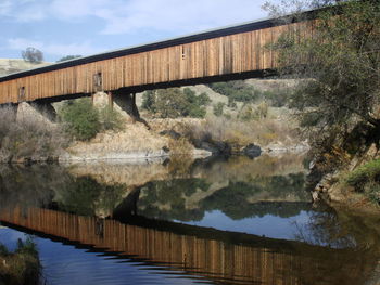 Footbridge over river against sky