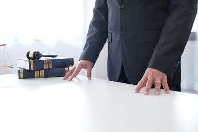 Midsection of lawyer standing at desk in courtroom