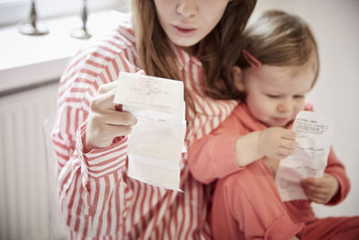 Mother and daughter with financial bills at home