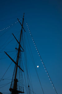 Low angle view of sailboat against clear blue sky