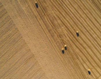 Directly above aerial shot of hay bales on agricultural field