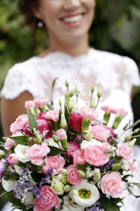 Close-up of woman holding pink flower bouquet