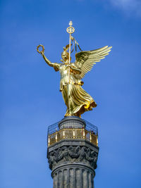 Low angle view of statue of liberty against blue sky