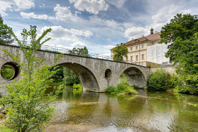 Arch bridge over river against sky