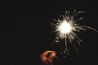 Cropped hand of man holding sparkler