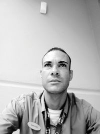 Portrait of young man against wall at home