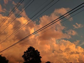 Low angle view of silhouette electricity pylon against sky during sunset