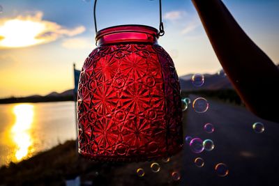 Close-up of illuminated red light against sky at sunset