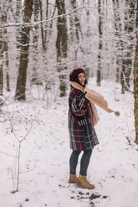 Full length of woman standing on snow covered field