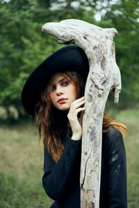 Portrait of woman standing against trees