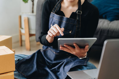 Midsection of woman using mobile phone