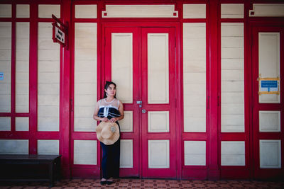 Portrait of woman standing against the wall