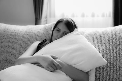 Midsection of woman resting on sofa at home