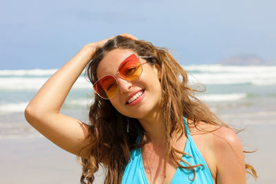 Portrait of young woman wearing sunglasses at beach