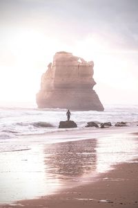Rock formations on beach against sky