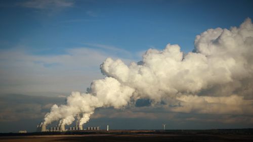 Smoke emerging from chimney on landscape