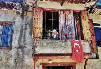 Man working on window of building