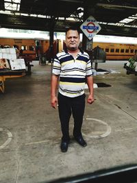 Full length portrait of young man standing in bus