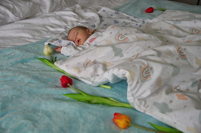 High angle view of baby sleeping on bed