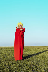 Portrait of woman standing on field against clear sky