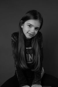 Portrait of smiling girl against black background