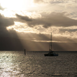 Sailboat sailing on sea against sky during sunset