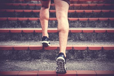 Low section of man walking on staircase