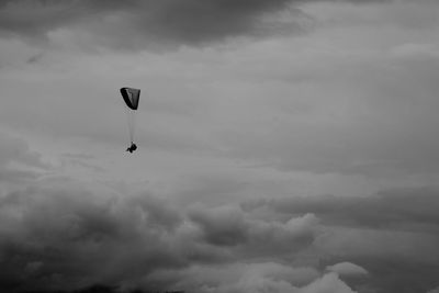 Low angle view of birds flying over cloudy sky