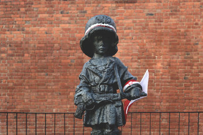 Close-up of statue against brick wall