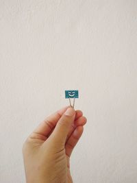 Close-up of hand holding paper clip