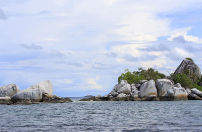 Rocks in sea against sky