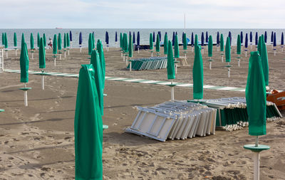 Wooden posts on beach against sky