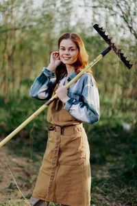 Portrait of young woman standing on field