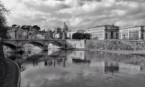 Bridge over river against cloudy sky