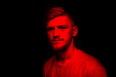 Portrait of young man against black background