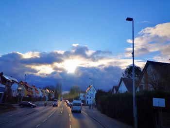 Cars on road amidst buildings against sky