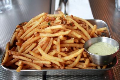 Close-up of meat and fries in plate on table