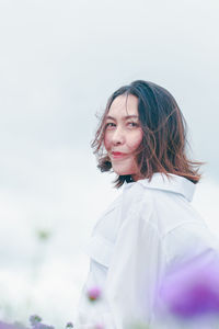 Portrait of smiling girl standing against white background