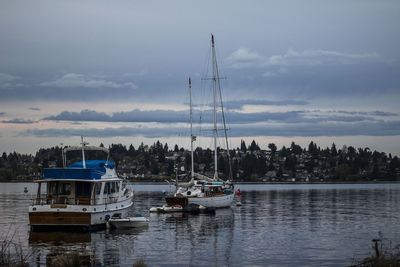 Boats moored on shore against sky