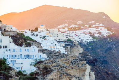 Traditional white cave houses on a cliff on the island santorini, cyclades, greece
