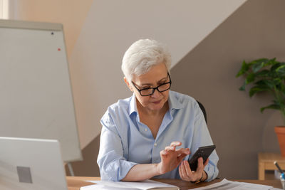 Female doctor examining patient at desk in office