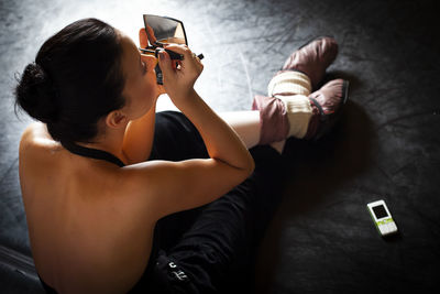 Side view of woman using mobile phone while sitting at home