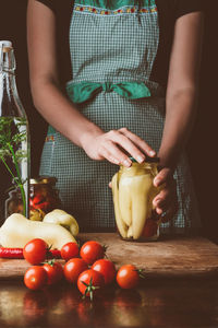 Midsection of man holding tomatoes on table